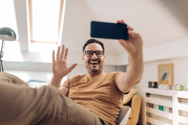 istock Young man having a video call and waving 1253904356