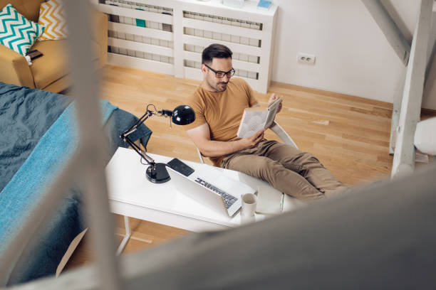 istock Young man reading a book and relaxing after work 1253904433