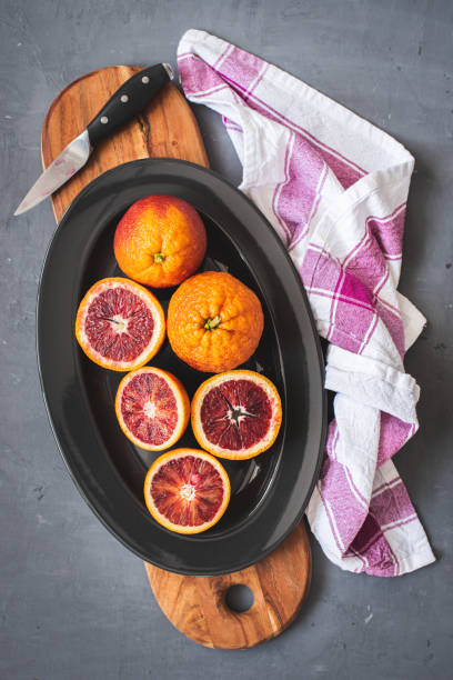 istock Fresh bloody oranges on a black plate on a dark gray background 1253904600