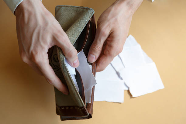 istock Empty wallet with paper in the hands of a man on a plain background 1253904701
