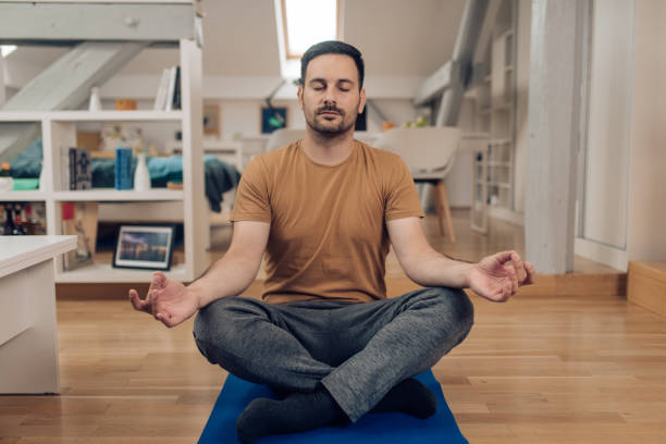 istock Young man meditating at home 1253905764