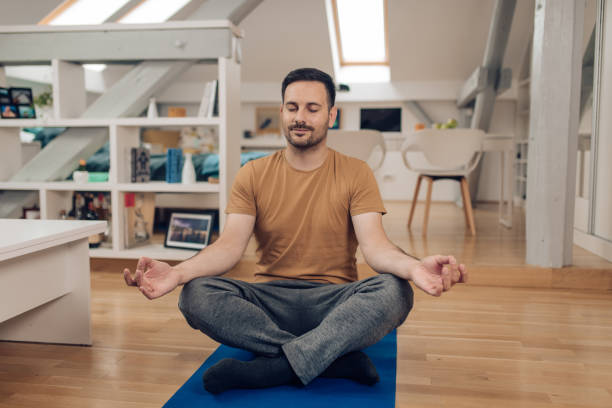 istock Young man doing yoga and meditation at home 1253905767