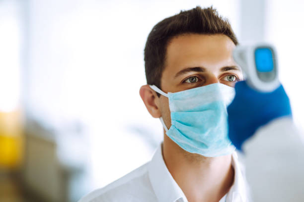 istock Visitors must go through fever measures using infrared digital thermometer check temperature measurement on the forehead. 1253907131