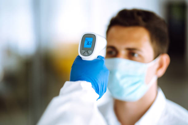 istock Hand in glove holding ir thermometer. 1253907432