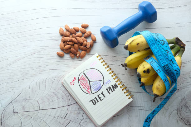 istock Diet plan with almond nut, dumbbells, banana on table 1253910342