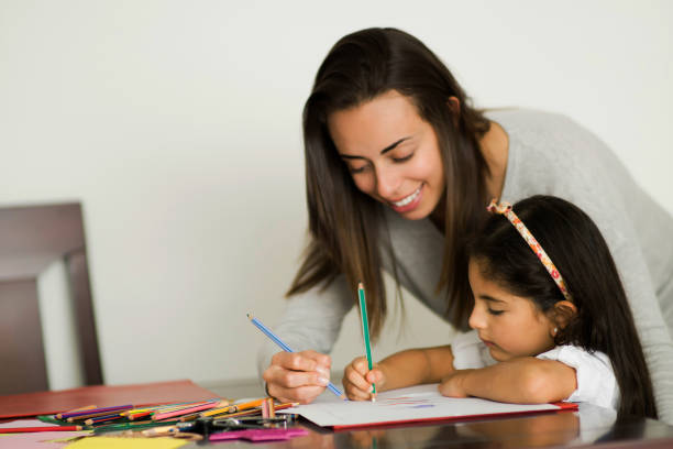 istock Loving mother helping daughter with her assignments while on lockdown 1253914030