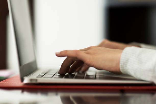 istock Close up of unrecognizable woman at home using her laptop 1253914059