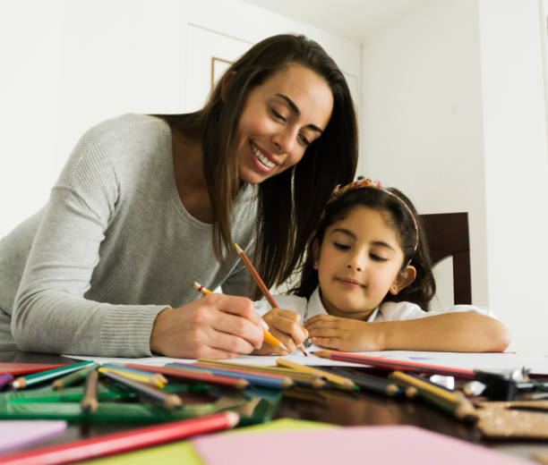 istock Loving mom helping daughter with her homework during lockdown 1253914065