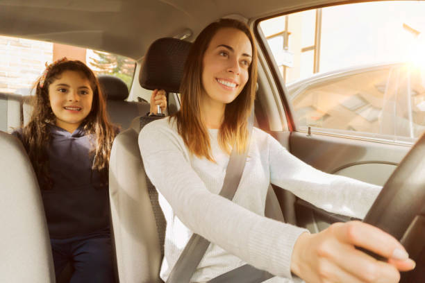 istock Young mom driving daughter to school both looking happy 1253914097