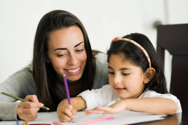 istock Mother helping her daughter with a school assignment during pandemic lockdown 1253914102
