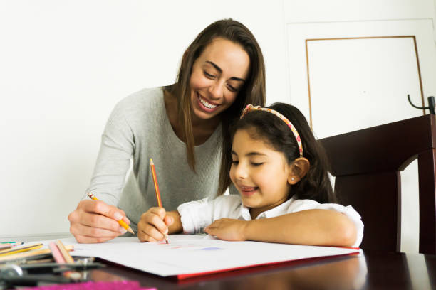 istock Cheerful mother helping her daughter with her assignment during lockdown 1253914107