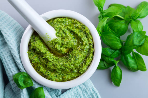 istock Closeup homemade basil pesto on a gray table. 1253918161
