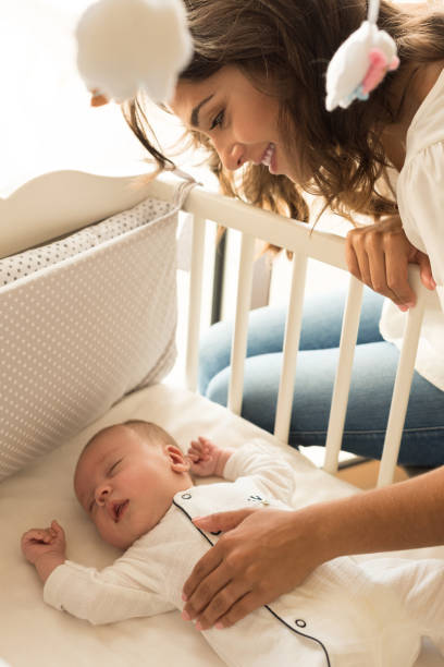 istock Mother putting baby to sleep 1253920246