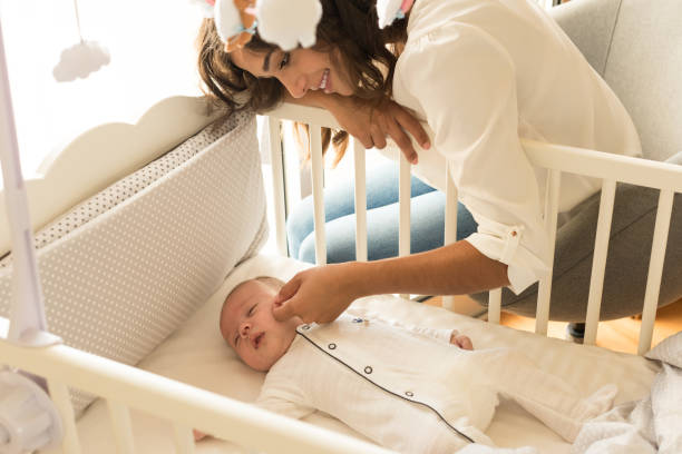 istock Mother putting baby to sleep 1253920255