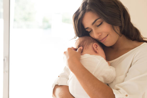mujer con bebé recién nacido - bebé fotografías e imágenes de stock