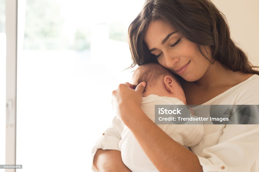 Woman with newborn baby Pretty woman holding a newborn baby in her arms Mother Stock Photo