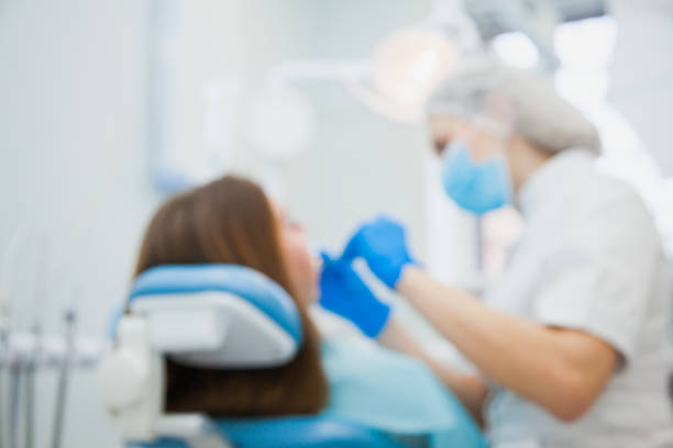 defocused, blurred image of dentist with patient at clinic office - dentist dental hygiene dental assistant dentist office imagens e fotografias de stock