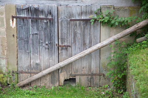 Old weathered barricaded barn entrance gate
