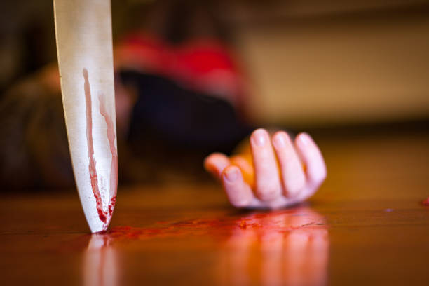 De cerca en un cuchillo ensangrentado plantado en un suelo de madera, una escena de matar - foto de stock