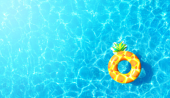 Pool water texture background with inflatable pineapple toy. Top view. With flare effect.