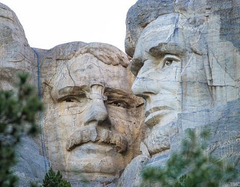 Detail of Mount Rushmore under a blue sky.
