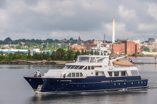New Bedford, Massachusetts, USA - July 1, 2020: Luxury yacht Casual Water leaving New Bedford under storm clouds
