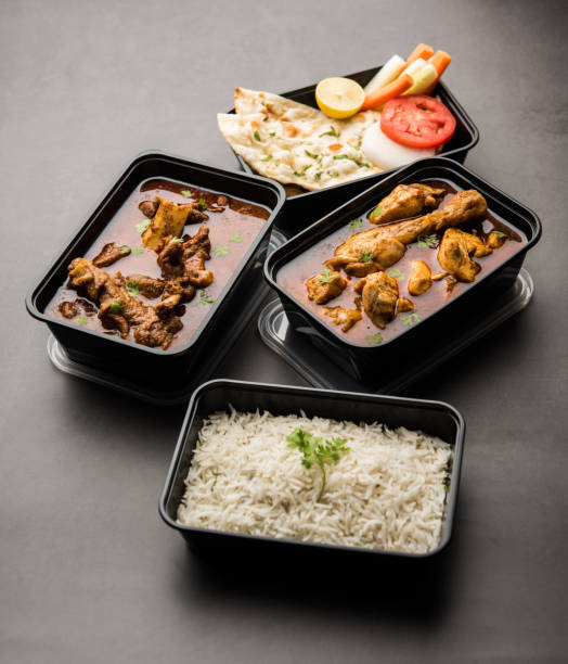 entrega de alimentos en línea - cordero y curry de pollo en recipiente de plástico - comida hindú fotos fotografías e imágenes de stock