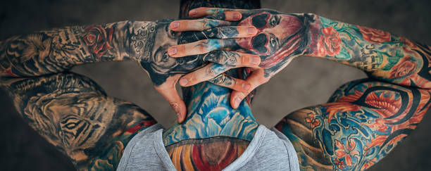 Man with whole body in covered in tattoos One man, modern man with whole body in covered in tattoos, rear view. body adornment rear view young men men stock pictures, royalty-free photos & images
