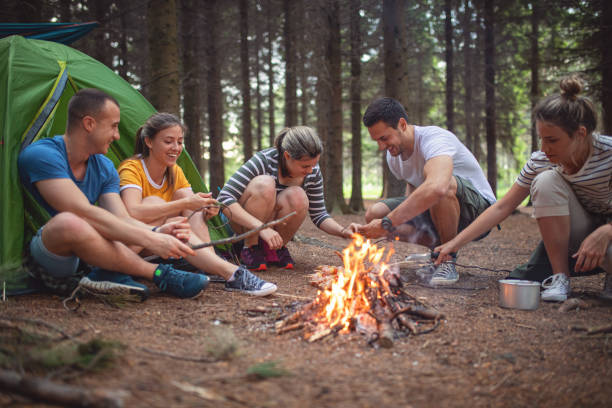 istock Couple camping with friends in a forest 1253944082