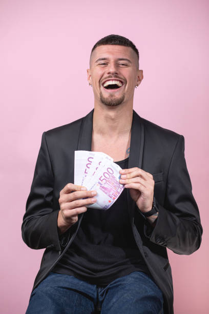 istock Joyful lottery winner holding his stack of money 1253944147