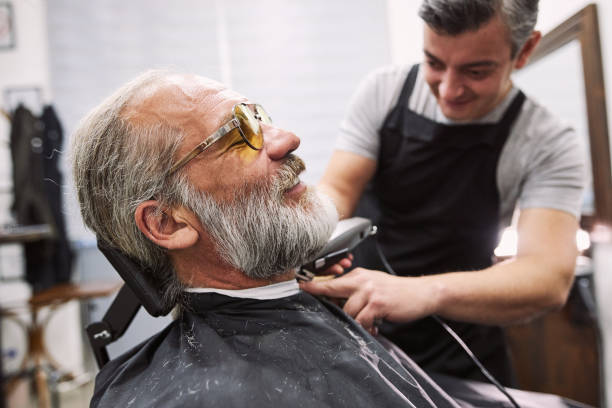 istock Side view of a senior man visiting a barber shop for a beard pamper 1253944164