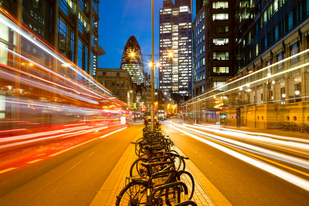 Traffic on Bishopsgate Street at Dusk, London, United Kingdom Busy street with traffic and light trails at dusk, London, England. gherkin london night stock pictures, royalty-free photos & images