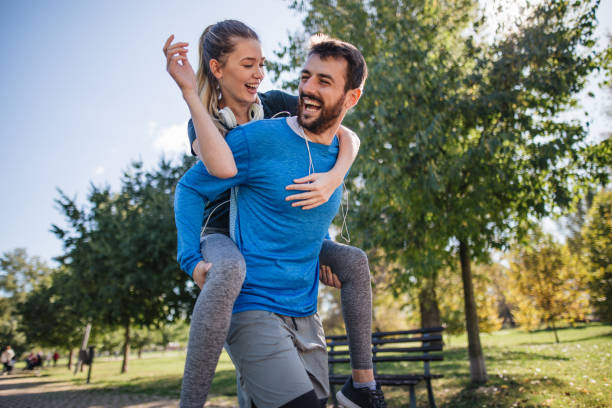 istock Strong man carrying his beautiful girlfriend on his back 1253944384