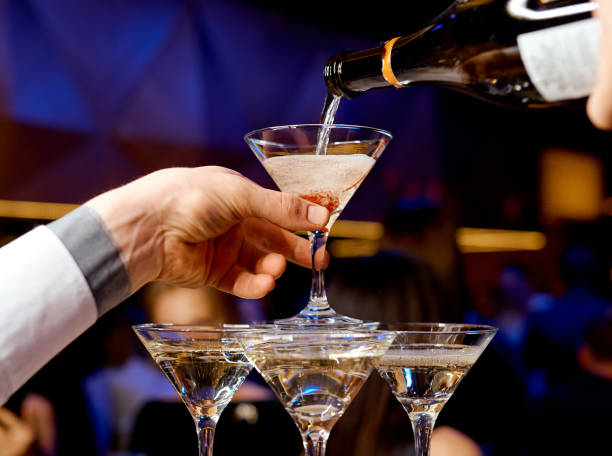 istock Waiter pours champagne into the upper tower 1253945790