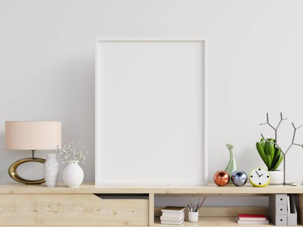 istock Poster mockup with vertical frame on table and white wall background. 1253952810