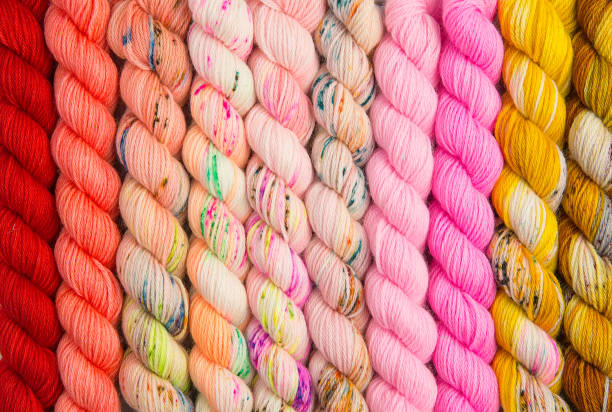 Warm colors of twisted yarn Warm colored hues of yarn twisted into hanks skein stock pictures, royalty-free photos & images