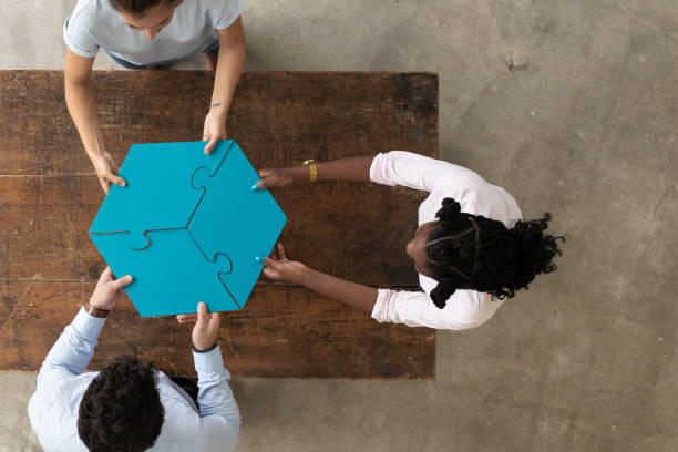 istock Professionals assembling 3 par puzzle piece, aerial view 1253956501