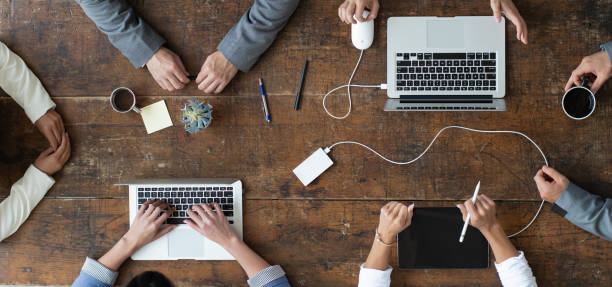 istock Business group at table from aerial view, sitting at rustic table 1253956509