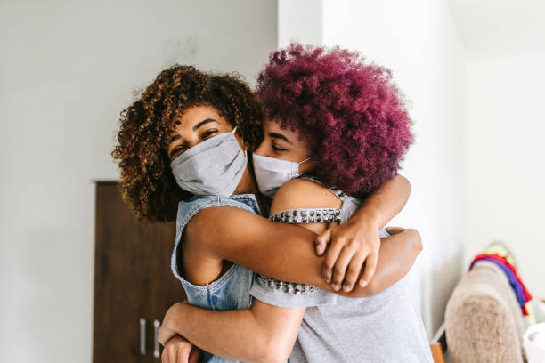 istock Covid-19: two curly women hugging each other 1253956573