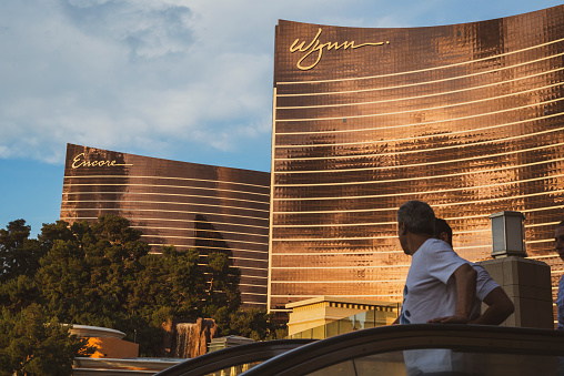 Two men descend an escalator on the Las Vegas Strip near the Wynn and Encore hotel and casino.