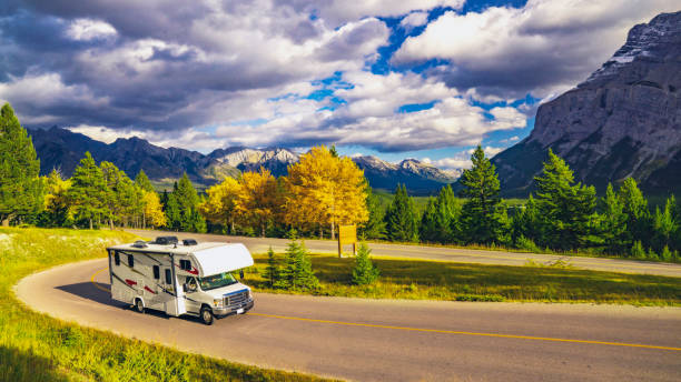 Recreational Vehicle Driving on Autumn Highway In Beautiful Mountains Wilderness Recreational Vehicle Driving on Autumn Highway In Beautiful Mountains Wilderness in Jasper, AB, Canada motor home photos stock pictures, royalty-free photos & images