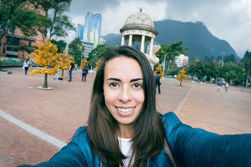 Cheerful woman taking a selfie while doing tourism with a toothy smile - Lifestyles