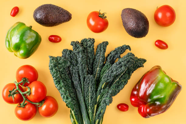 istock Black curly italian kale, tomatoes, avocado, pepper on orange background. 1253963588