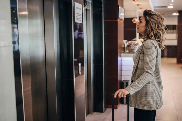 istock Beautiful woman standing by the elevator in hotel 1253965920