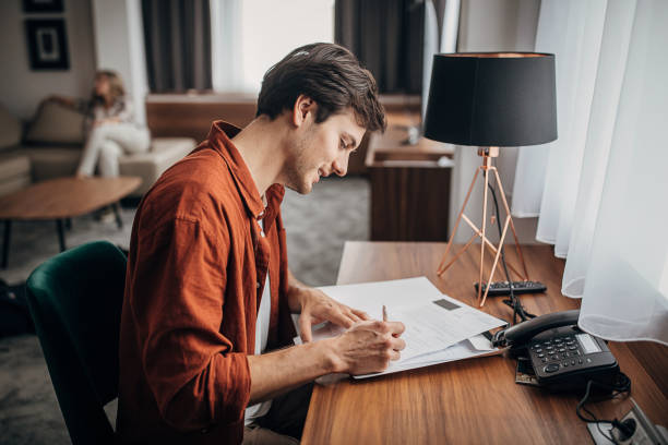 istock Man looking at brochures in hotel room 1253966632
