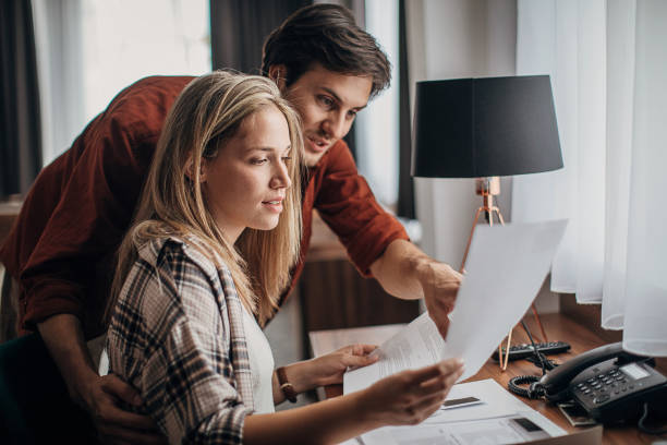 istock Couple looking at brochures in hotel room 1253966697