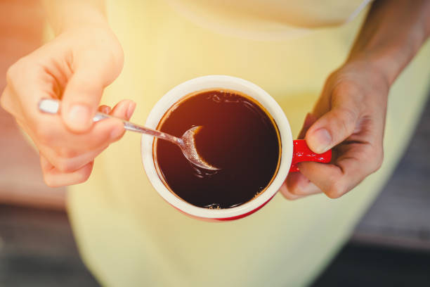 istock hand use spoon mix coffee in the morning. 1253967541
