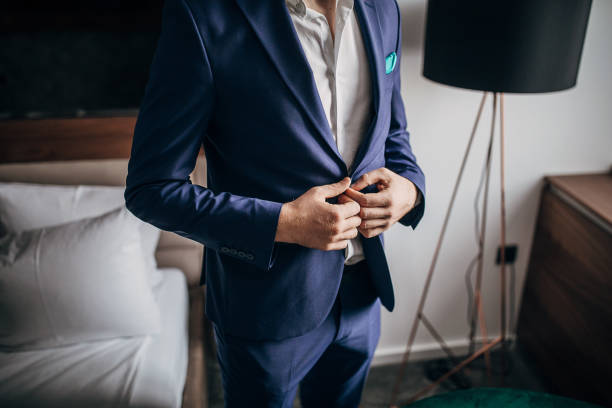 istock Modern man in blue suit in hotel room 1253970926