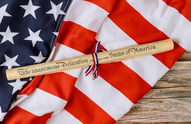 istock Fourth of July Day. Declaration of Independence parchment roll document with US flag. 1253970956