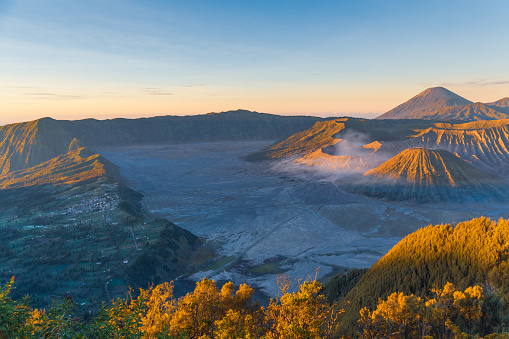Early morning view of the Bromo caldeira in East Java in Indonesia. The volcanic formation of a few volcanoes, with the famous volcano Bromo and the Semeru volcano in the background attract everyday large crowds of visitors on the mountain top for sunrise. nature landscape background